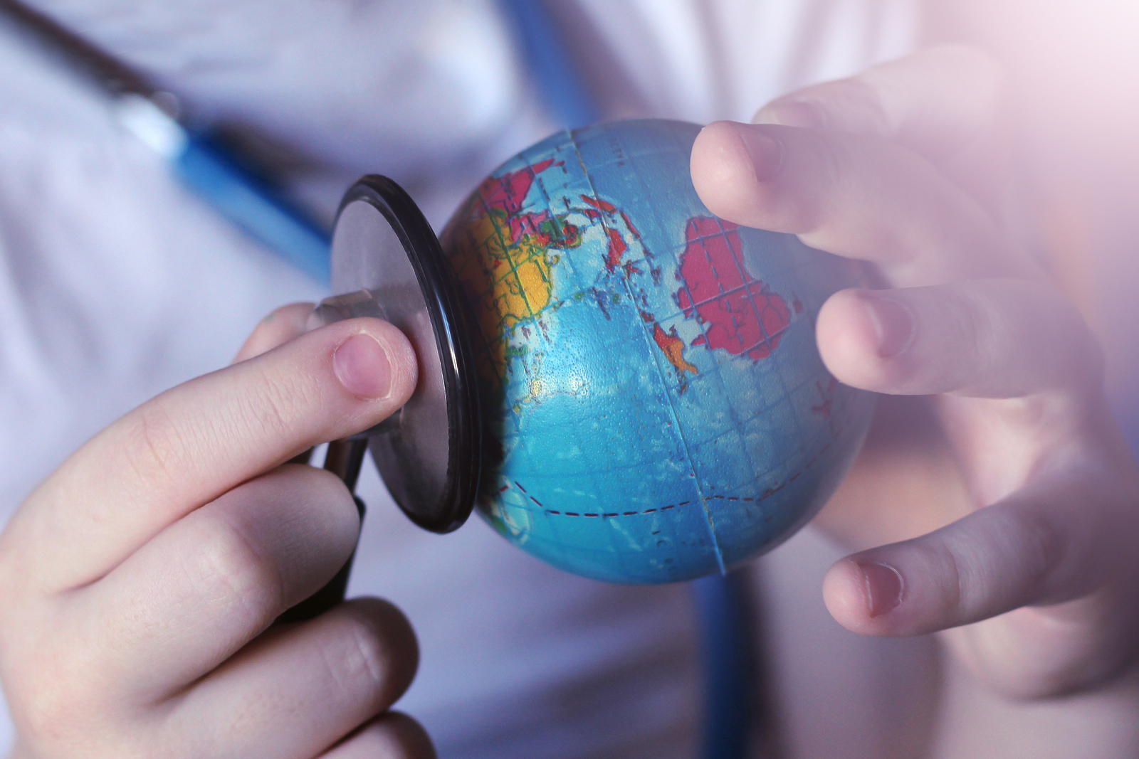 Stethoscope and globe in children's hands, blue toned